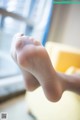 A close up of a person's bare feet on a bed.