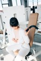 A woman sitting on a bench in a gym.