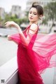 A woman in a red dress is posing for a picture.