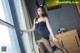 A woman in a black dress and bunny ears posing for a picture.