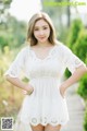 A woman in a white dress posing for a picture.