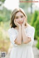 A woman in a white dress posing for a picture.