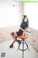 A woman sitting on top of a stool in a room.