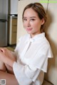 a woman sitting on top of a couch next to a refrigerator