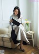 A woman sitting on a chair reading a book.