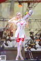 A woman in a white and red outfit holding a toy gun.