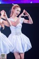 A woman in a white dress dancing on a stage.