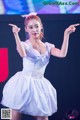 A woman in a white dress dancing on a stage.