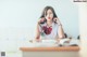 A woman sitting at a desk with her hand on her chin.