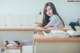 A woman sitting at a desk in a classroom.