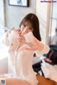 A woman in a white shirt is washing her hands.