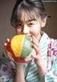 A woman in a kimono holding a colorful ball in her hands.