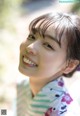 A woman in a kimono smiles at the camera.