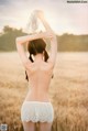 A woman in a white lingerie standing in a field.