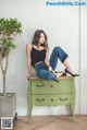 A woman sitting on top of a green dresser.