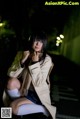 A woman sitting on the ground in the dark.