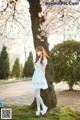 A woman standing next to a tree in a park.