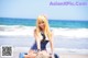 A woman sitting on a rock on the beach.