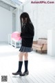 A young woman holding a pink balloon in a room.