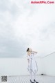 A woman in a white dress standing on a roof.