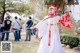 A woman dressed in a white and red outfit holding a sword.