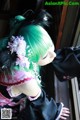 A woman with green hair and a flower in her hair.