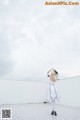 A woman in a white dress standing on top of a roof.