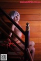 A woman in a bikini sitting on a wooden staircase.