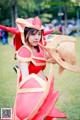 A woman in a red and gold costume holding a sword.