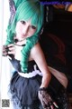 A woman with green hair wearing a black and white dress.