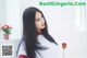 A woman with long black hair holding a red rose.