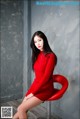 A woman in a red dress sitting on a red chair.