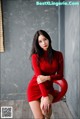 A woman in a red dress sitting on a red chair.