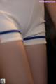 A close up of a person wearing a white shirt and blue shorts.