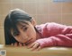 A young girl laying on top of a bathtub.