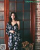 A woman standing in front of a wooden door.