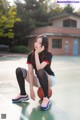 A woman sitting on a basketball on a court.