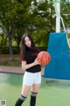 A woman holding a basketball on a basketball court.