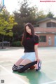 A woman sitting on a basketball court with a basketball.