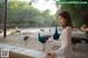 A woman sitting on a bench in front of a group of peacocks.