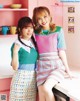 A couple of young women standing next to each other in a kitchen.