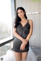 A woman in a black lingerie posing in a bathtub.