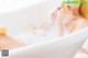 A woman sitting in a bathtub eating a donut.