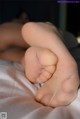 A close up of a person's foot on a bed.