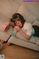 A woman laying on a couch holding a bottle of water.