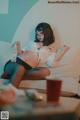 A woman sitting on a couch holding a bottle of water.