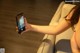 A woman sitting on a couch holding a cell phone.