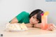 A young girl laying on a table next to a plate of food.