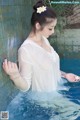 A woman in a white shirt is standing in a pool.