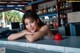 A woman leaning on a counter in front of a bar.